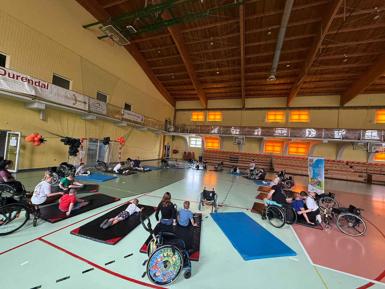 Uczestnicy obozu Aktywnej Rehabilitacji dla dzieci podczas ćwiczeń na materacach w hali Kompleksu Sportowego Arena Żagań, 2-10.07.2025 r.