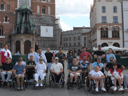 Dziesięcioro uczestników i kadra obozu Aktywnej Rehabilitacji na rynku w Krakowie, 23.08-3.09.2025 r.