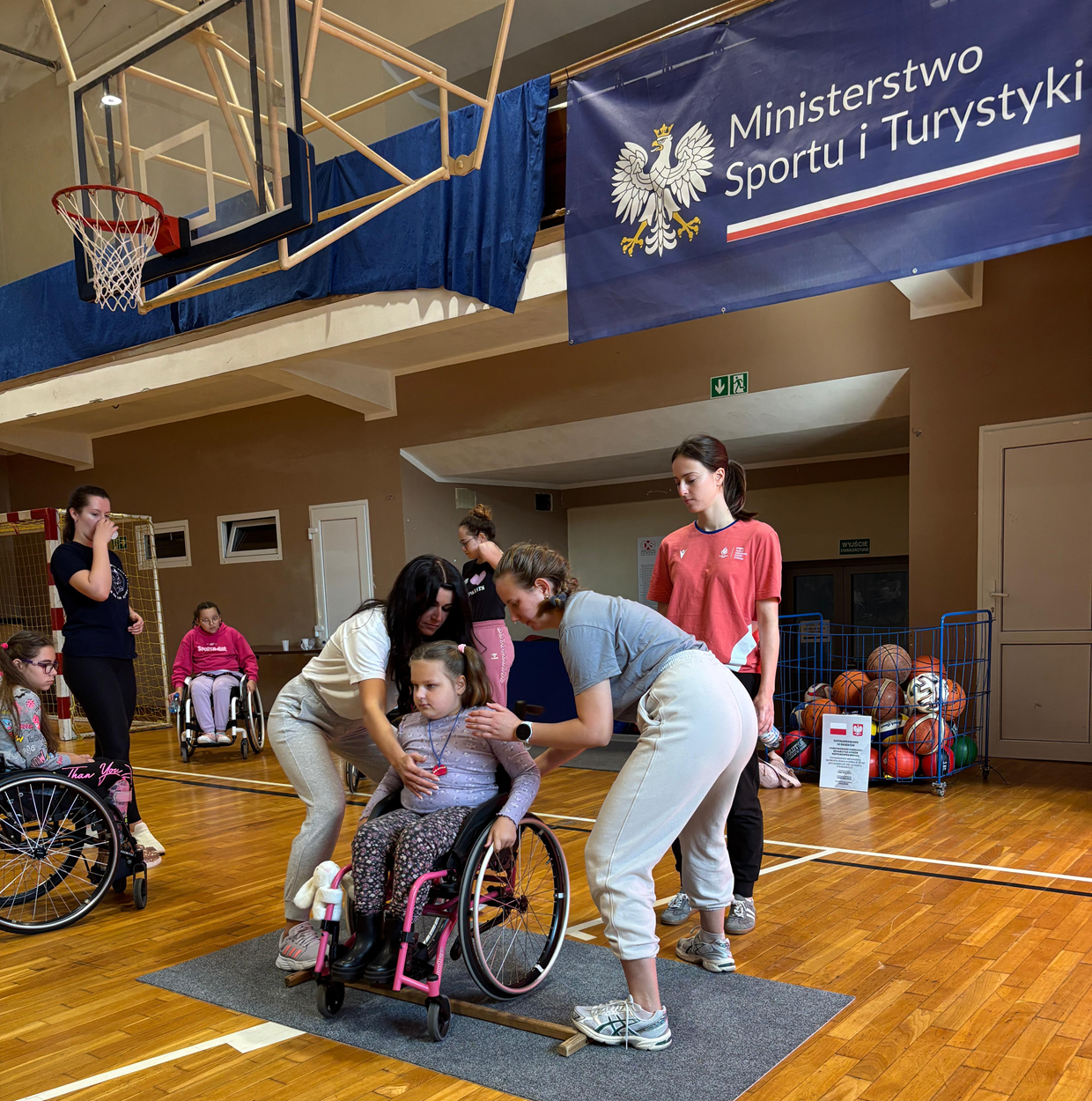 Zajęcia na sali z techniki jazdy na wózku - nauka pokonywania progu. Obóz Aktywnej Rehabilitacji dla dzieci w Cetniewie 21-30.09.2025 r.