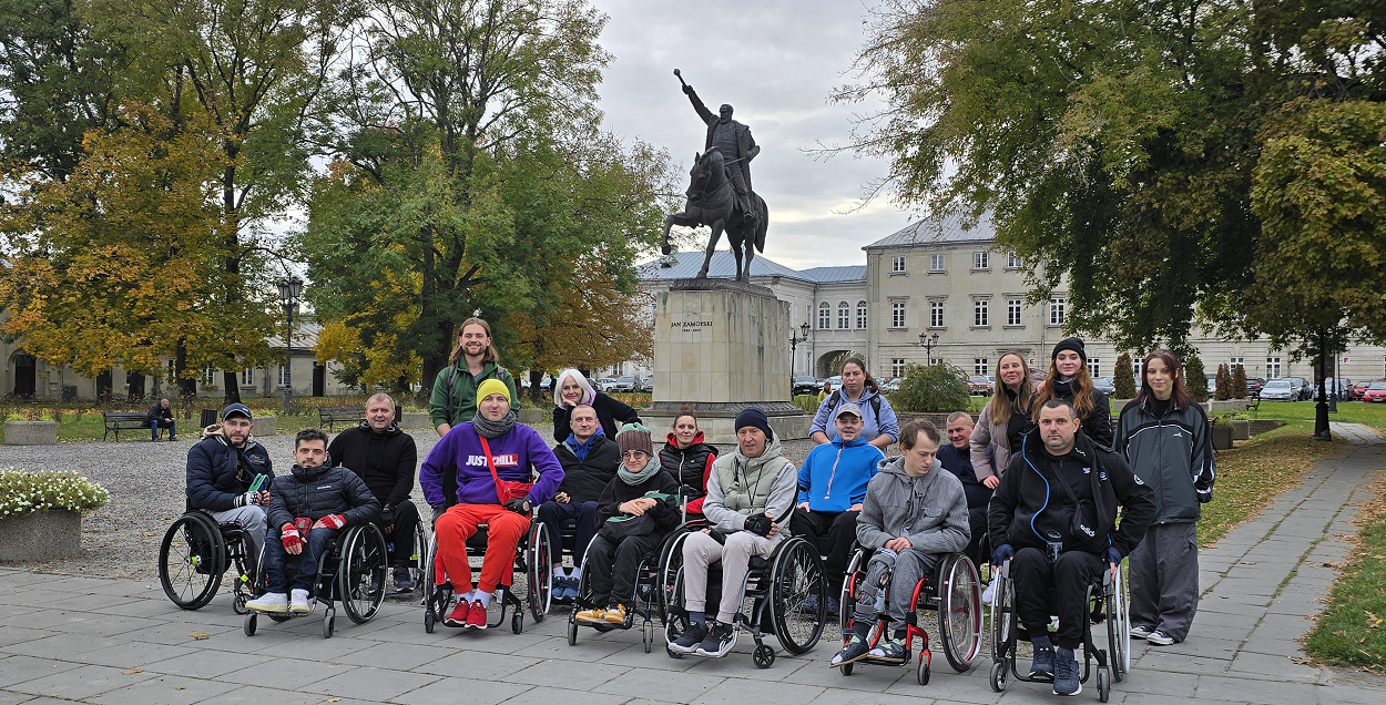 Dziesięcioro uczestników oraz kadra obozu Aktywnej Rehabilitacji 13-24.10.2025 w Zamościu przed pomnikiem Jana Zamojskiego