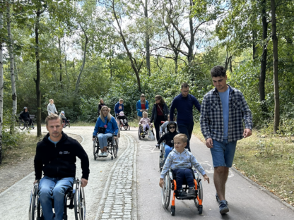 Spacer w parku. Uczestnicy i kadra Warsztatu Aktywnej Rehabilitacji dla dzieci i rodziców w Katowicach, 22-24.08.2025 r.